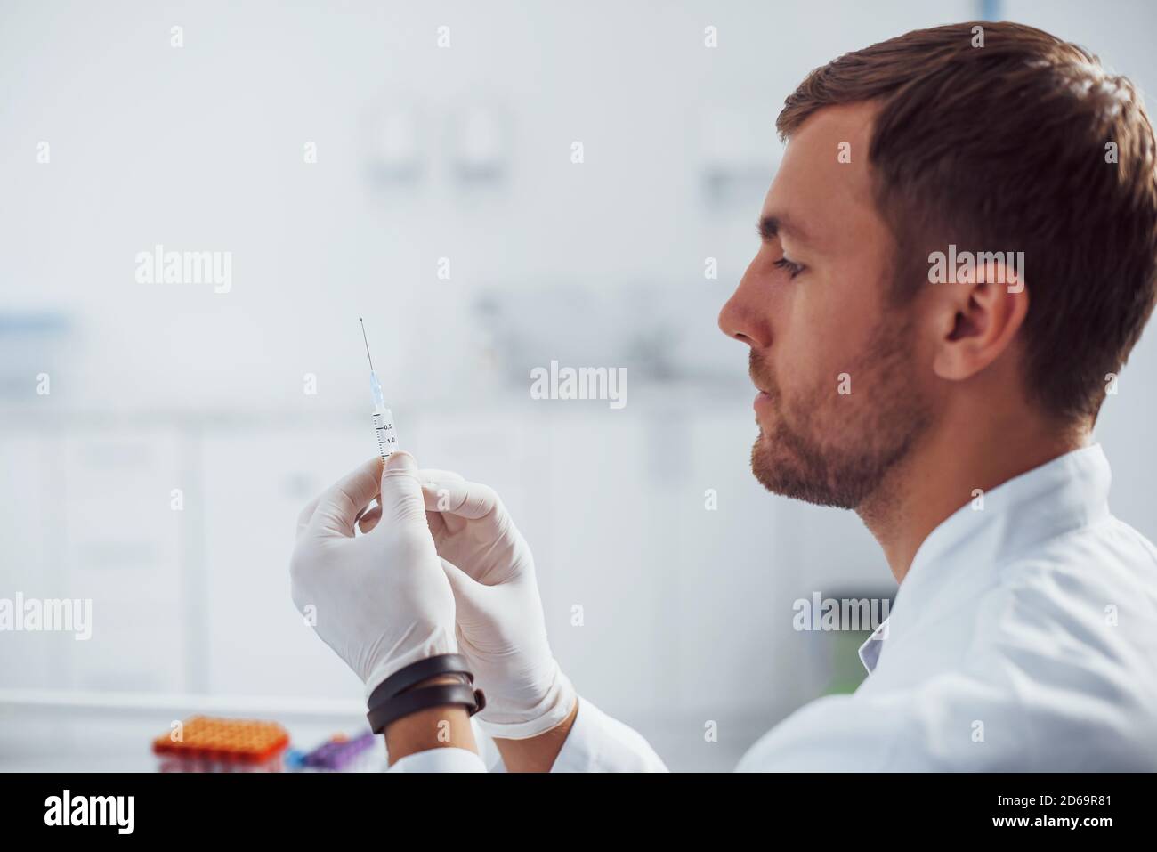 Doctor Sampling Male doctor with syringe is preparing for the blood sampling in the ...