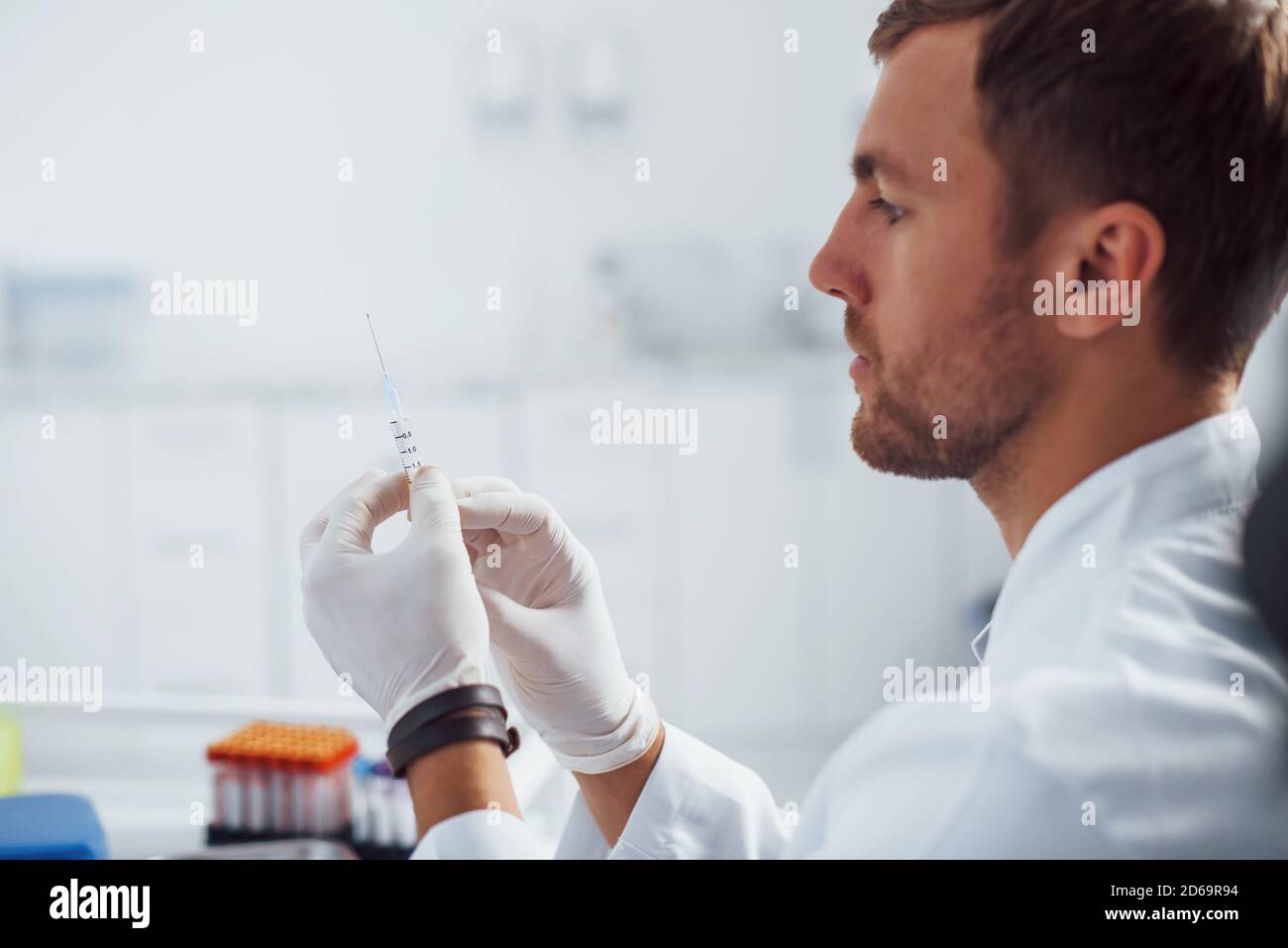 Doctor Sampling Male doctor with syringe is preparing for the blood sampling in the ...