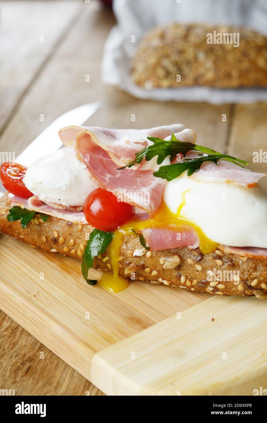 Bacon And Poached Eggs Sandwich On The Cut Board Stock Photo - Alamy