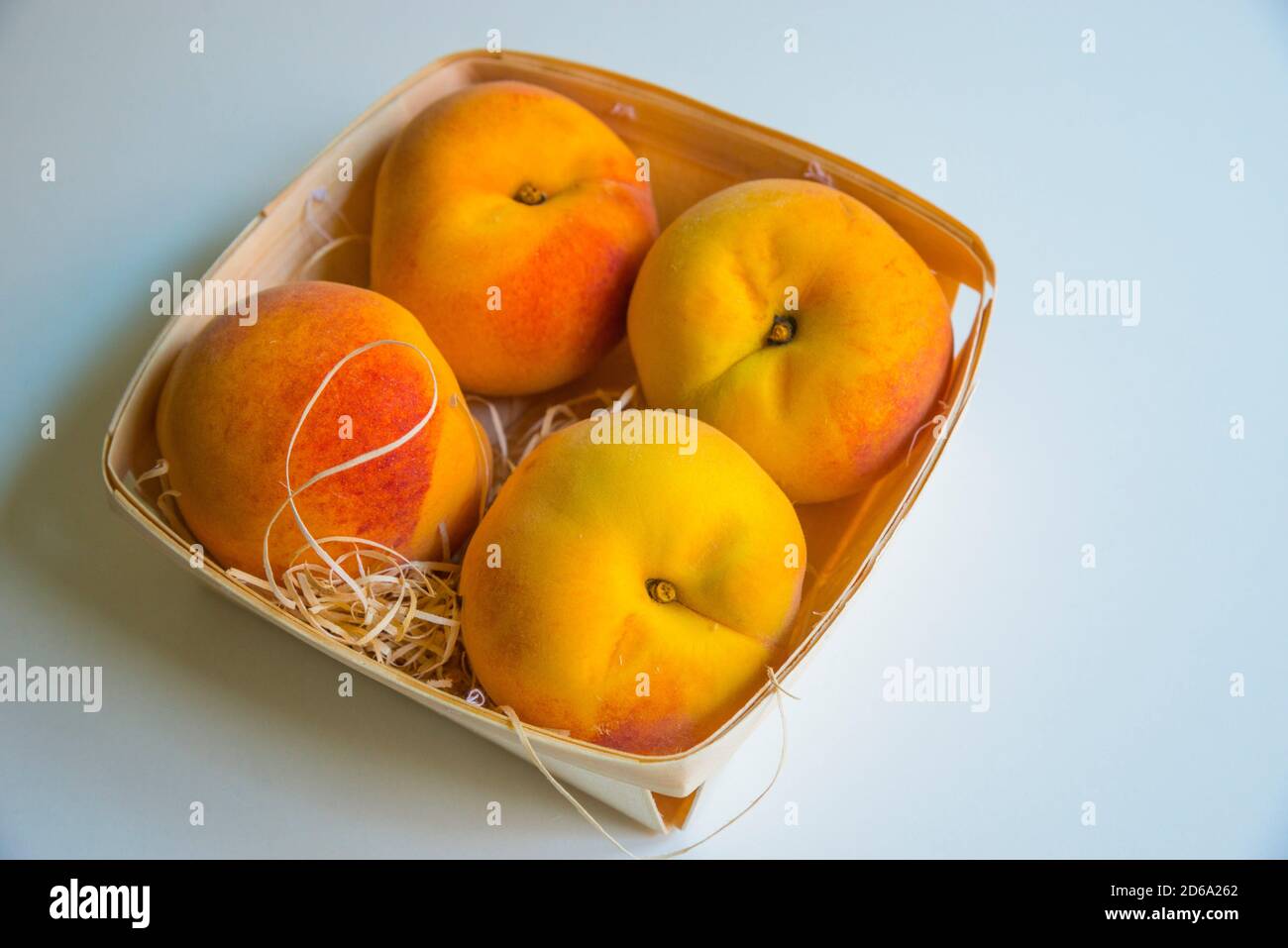 Four peaches in a basket Stock Photo Alamy