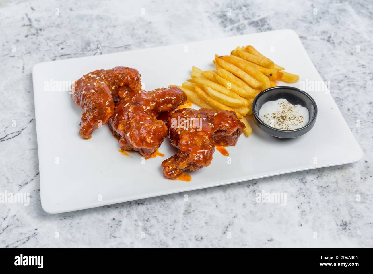 Hot and spicy buffalo chicken wings and crispy french fries with white