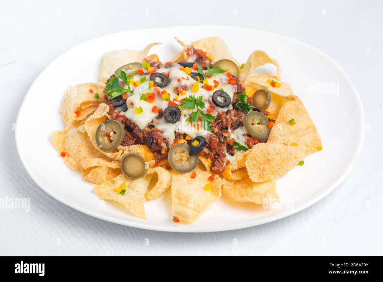 Mexican Famous Food Spicy Ground Beef Nachos. Heated crunchy tortilla chips with melted cheese and jalapeno served a snack food. Stock Photo