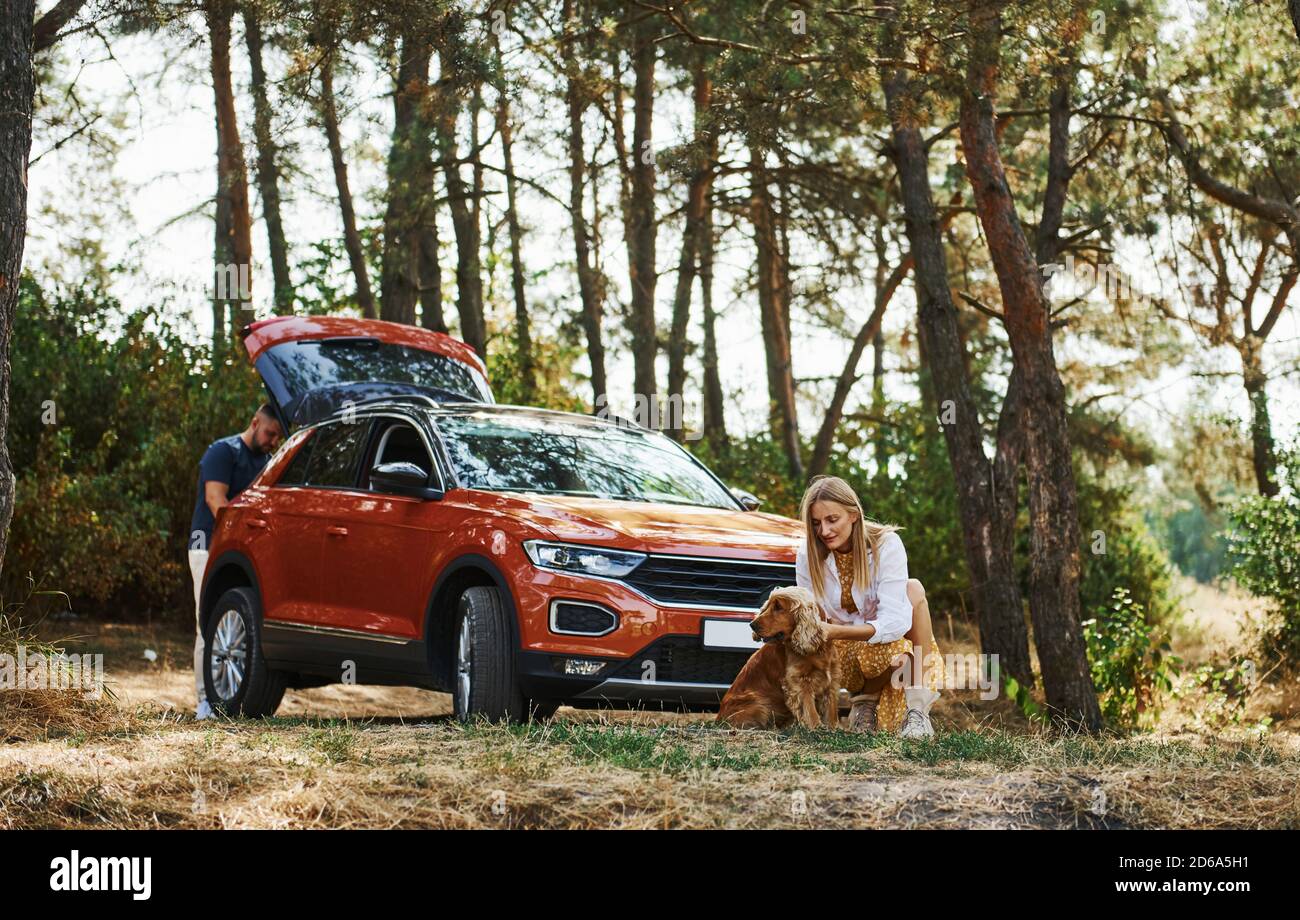 Couple with dog have weekend outdoors in the forest with car Stock ...