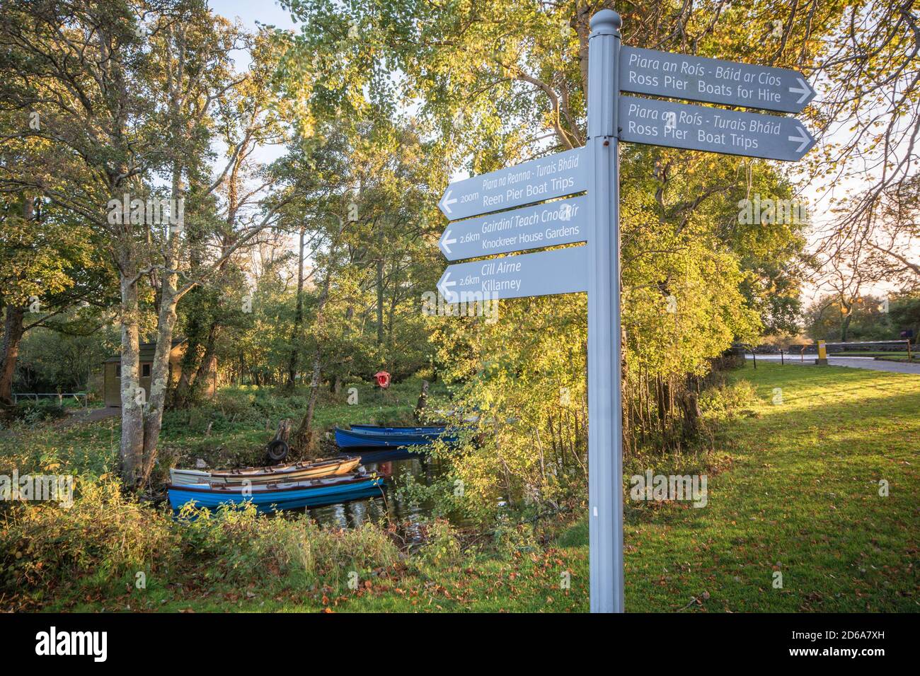 Signpost of attractions and activities against a backdrop of row boats near Ross Castle in the Killarney National Park in Kerry in Ireland Stock Photo