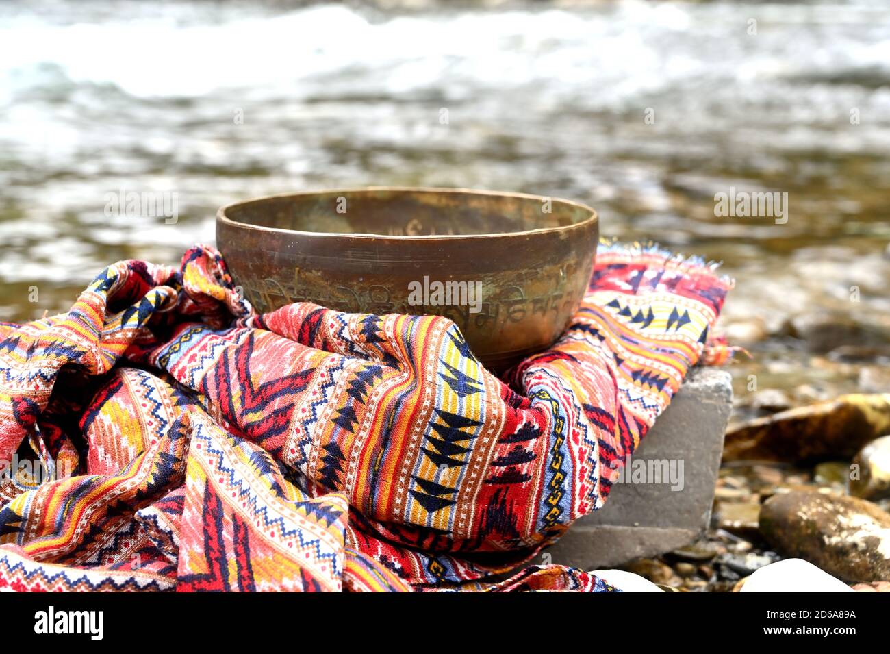 Copper tibetan singing bowl on the riverside Stock Photo
