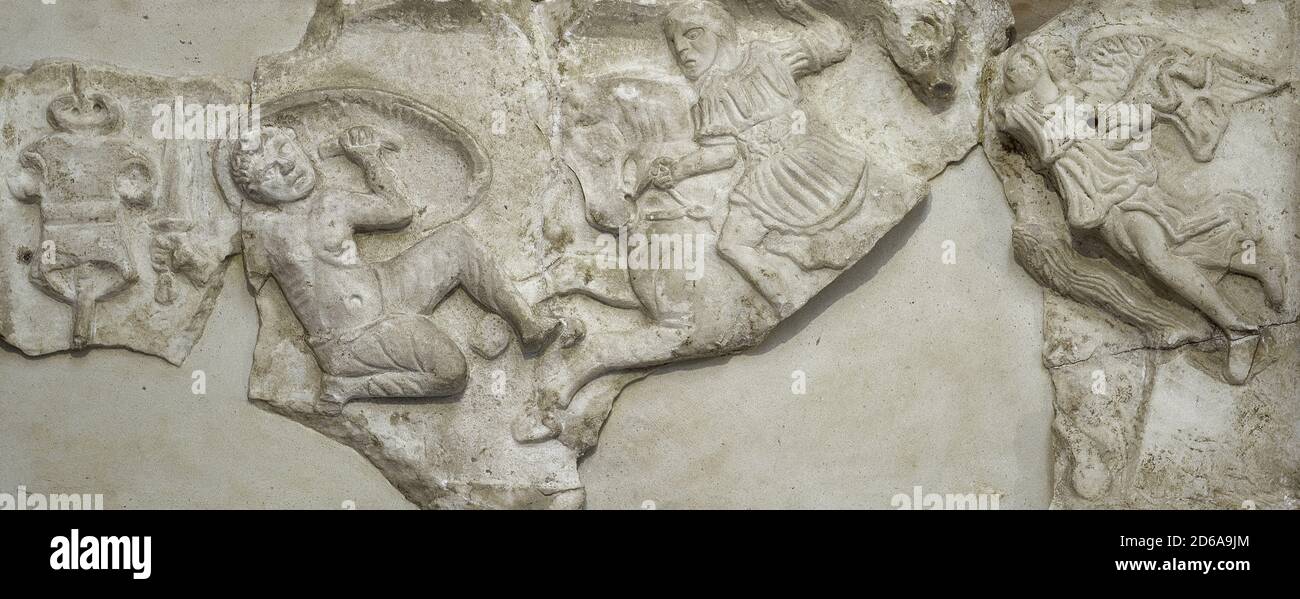 Relief of a triumphal monument commemorating Maximianus' victory over the Franks (Barbarians) in 296 AD. The reliefed slab, dated around 300 AD. It depicts the emperor as a triumphal horseman, alongside a tropaeum with chain armour. Above it, a torc. On the sides, a winged goddess Victory and a Roman military trophy. National Museum of Roman Art. Merida. Extremadura, Spain. Stock Photo