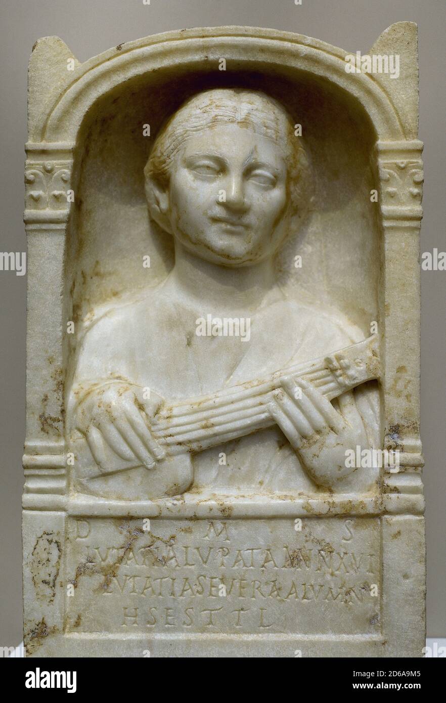 Roman era. Stele of Lutatia Lupata. The young Lutatia is depicted playing a stringed instrument, of the 'pandarium' type. The text gives us the name and age (16 years old) of the deceased, as well as the name of the dedicator Lutatia Severa. 60 x 36,50 cm. Marble. 2nd century AD. National Museum of Roman Art. Merida, Extremadura, Spain. Stock Photo