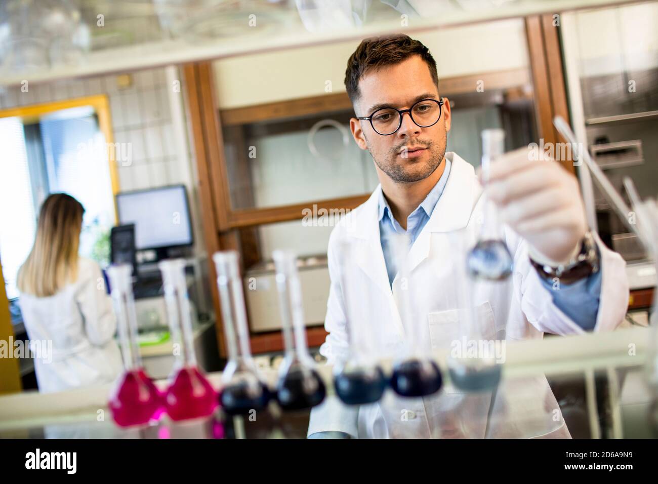 Young researcher checking test tubes in the laboratory Stock Photo