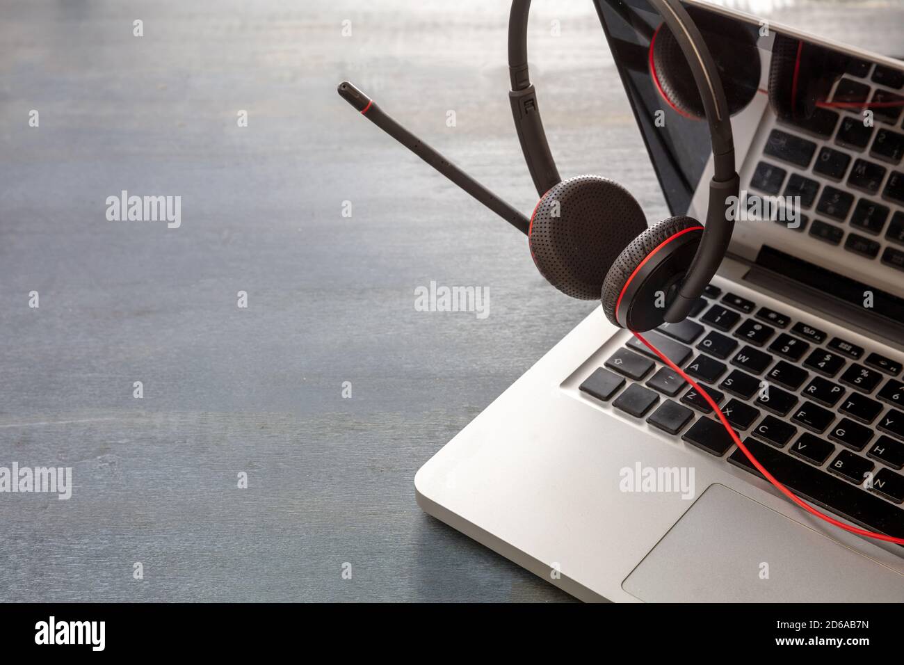 Home office, call center concept. Customer service support, help desk, communication. Headset and laptop on blue wooden desk, closeup view, copy space Stock Photo
