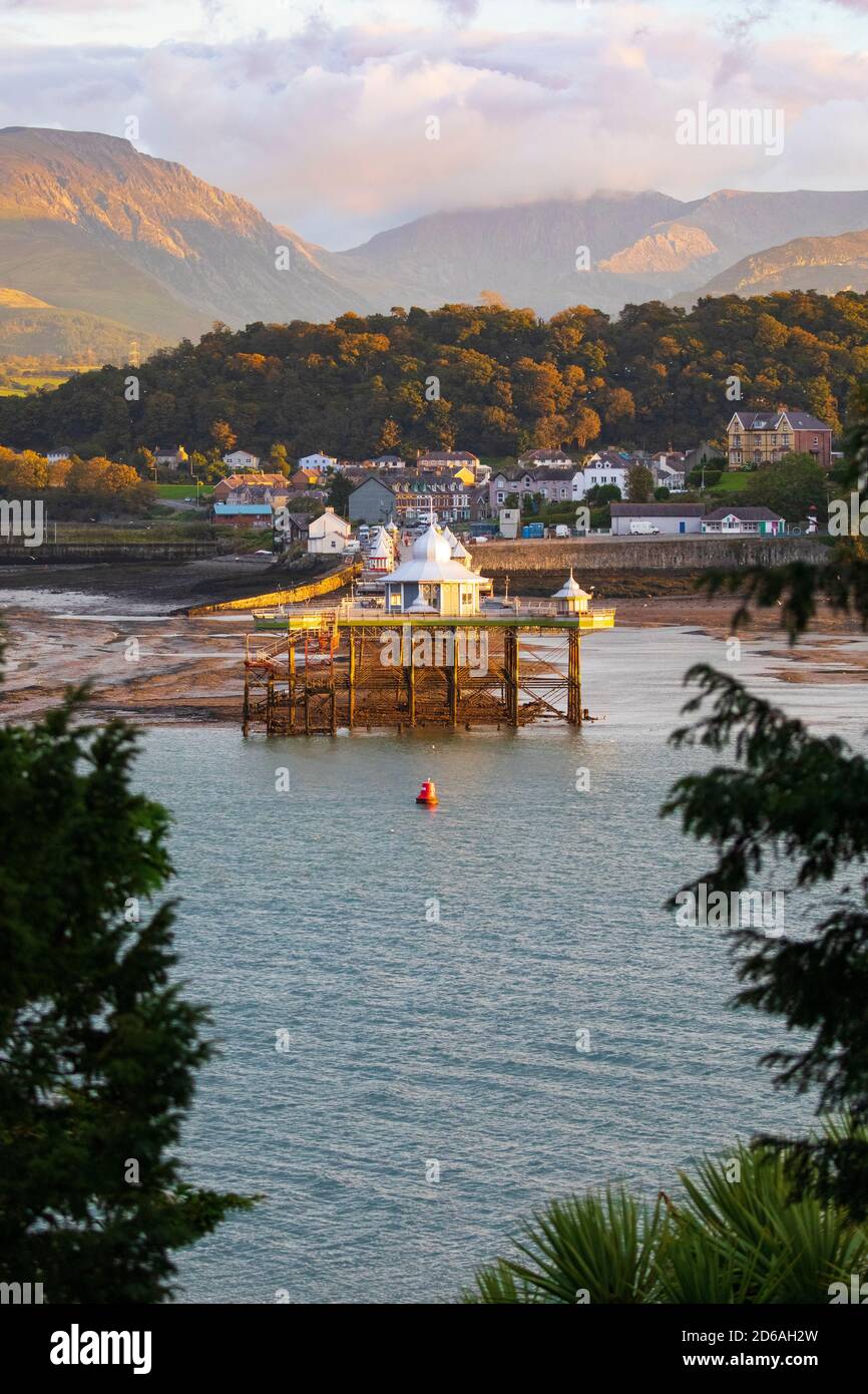 Bangor, North Wales, 15th October 2020. UK Weather: A spectacular end to the day as the sun sets across the Menai Straights painting both Bangor Pier and the mountains in Snowdonia National Park with golden light.  © DGDImages/AlamyLiveNews Stock Photo