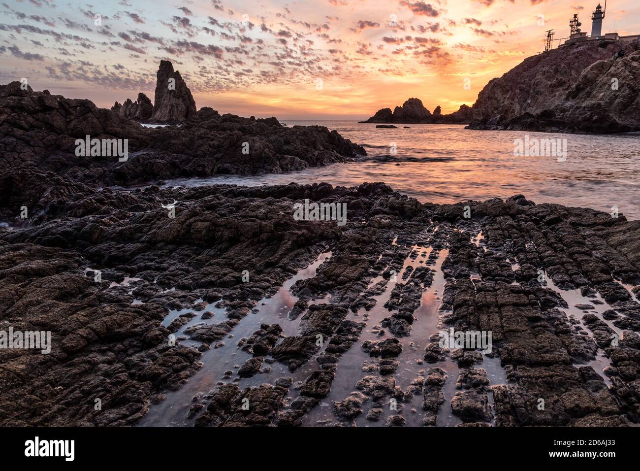 Nice sunset on a coast full of big rocks Stock Photo - Alamy