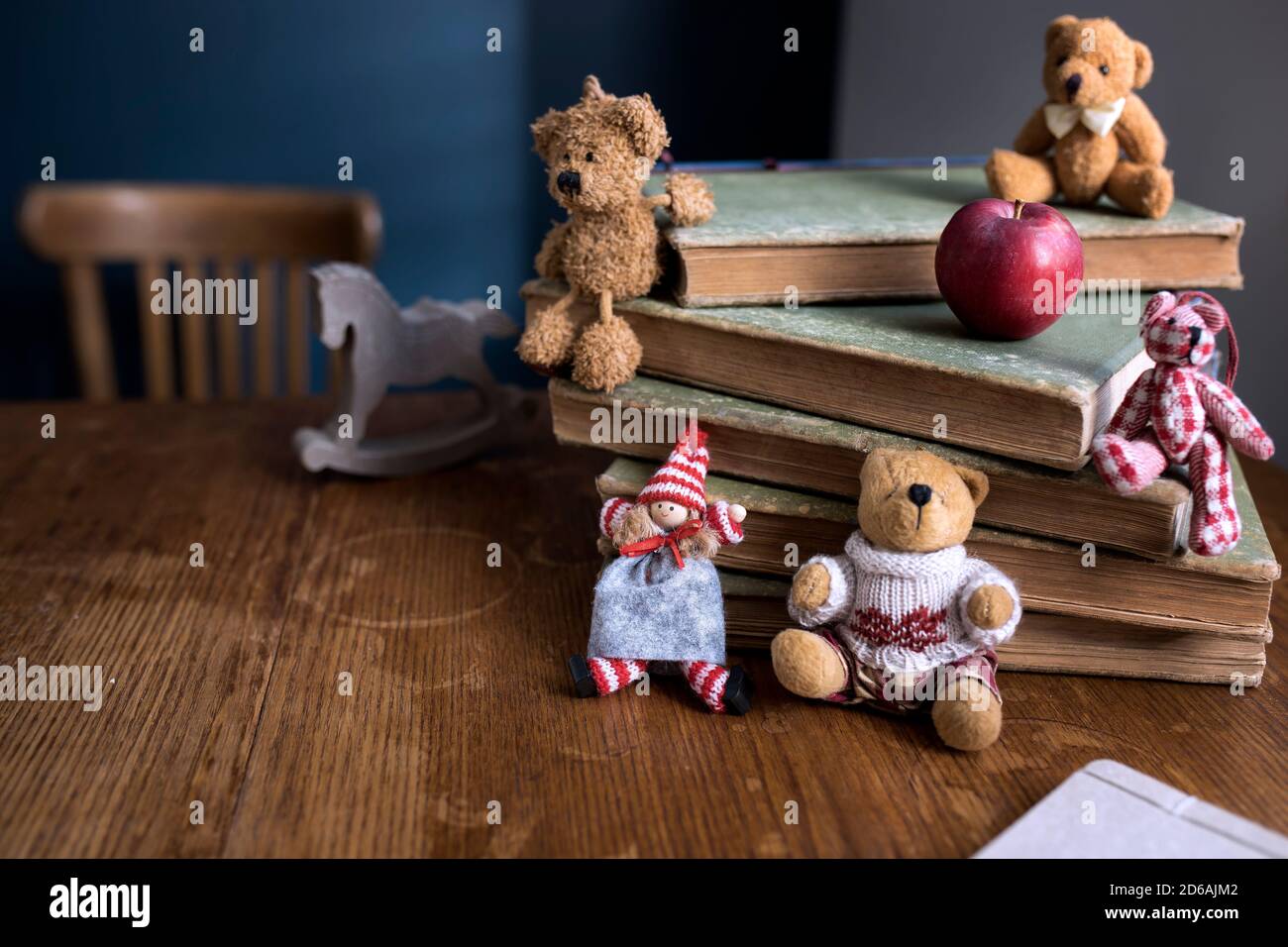 A Christmas doll and bears sit on a stack of old books. Copy space. Selective focus Stock Photo