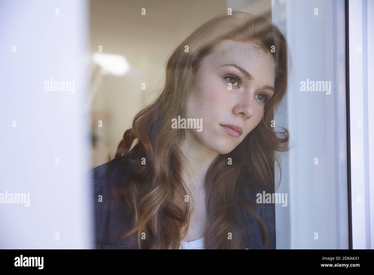 Woman looking out of the window at home Stock Photo - Alamy
