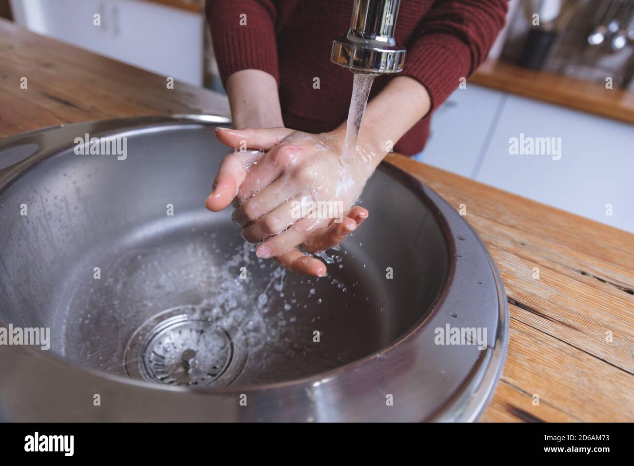 Mid section of woman washing her hands in the sink Stock Photo