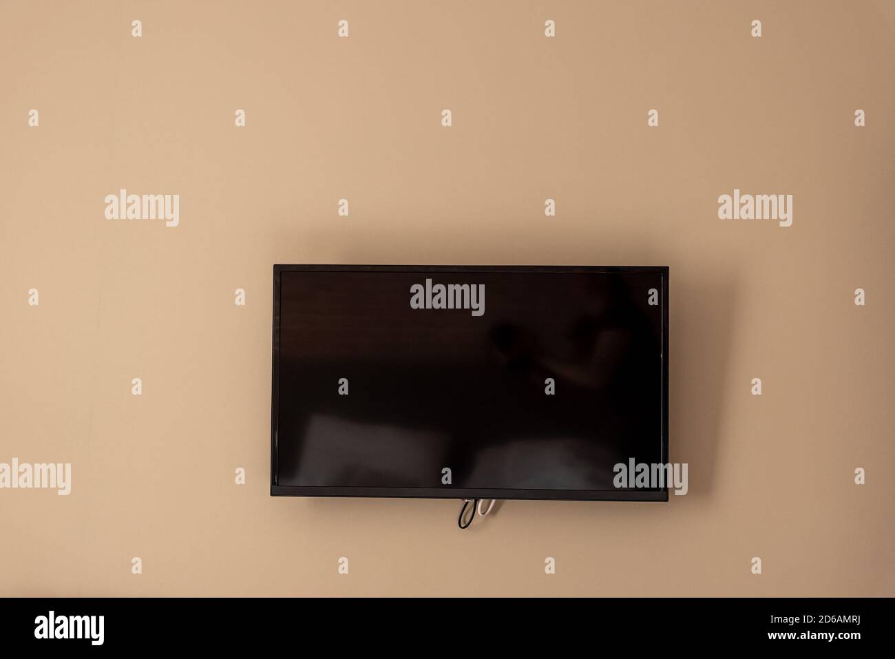 Big TV screen on beige wall, home cinema system Stock Photo