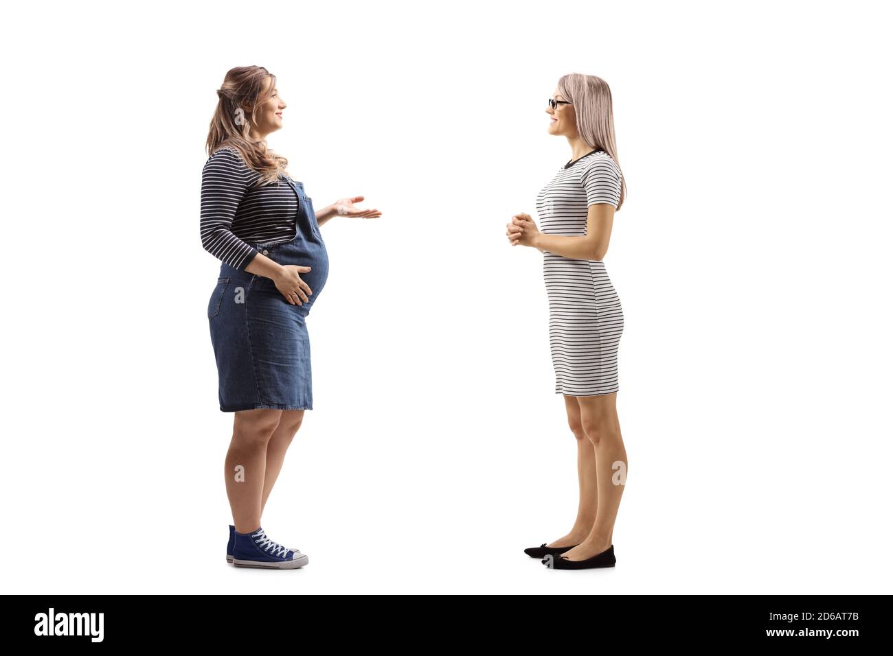Full length profile shot of a pregnant woman and a blond woman having a conversation isolated on white background Stock Photo