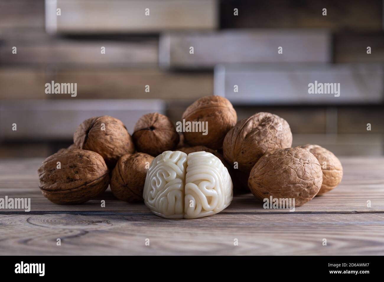 Walnuts like healthy food for the brain. Shape of human brain is surrounded by walnut kernels. It symbolizes how brain similarity with walnuts and Stock Photo