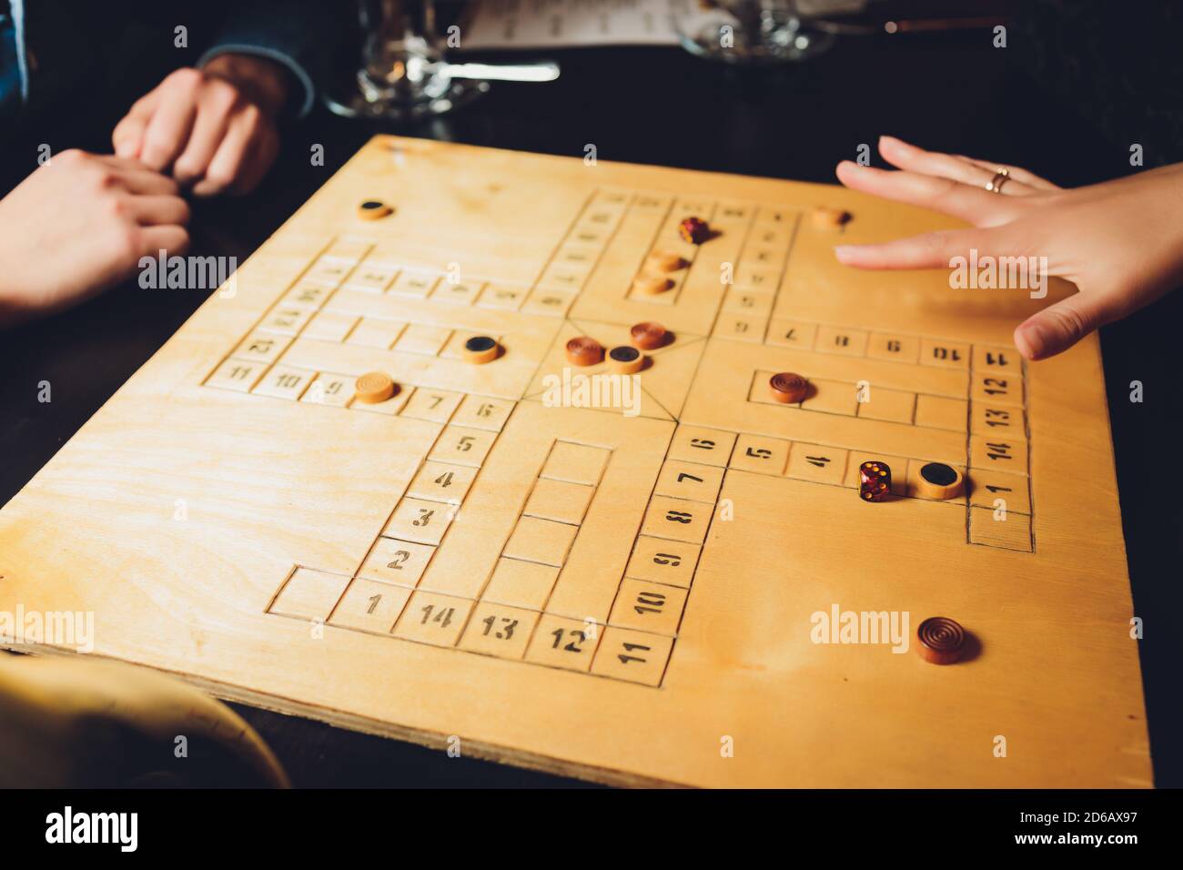 Two players playing against each other the game backgammon outside, outdoors. Game board trick track play fun leisure, recreation. Stock Photo