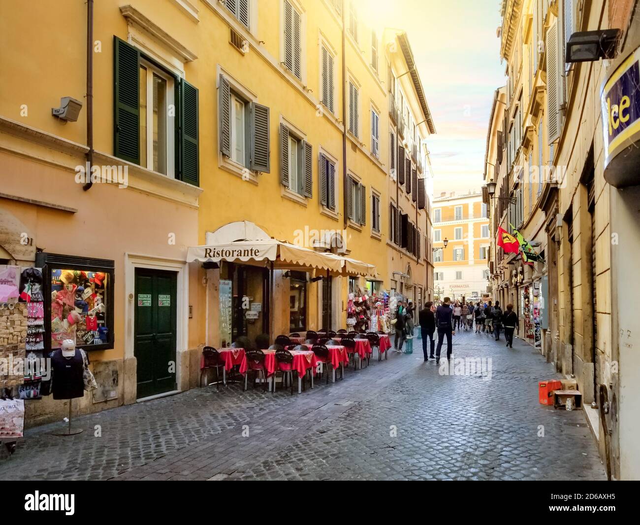 A cobblestone side street with sidewalk cafes and souvenir shops in the historic center of Rome, Italy Stock Photo