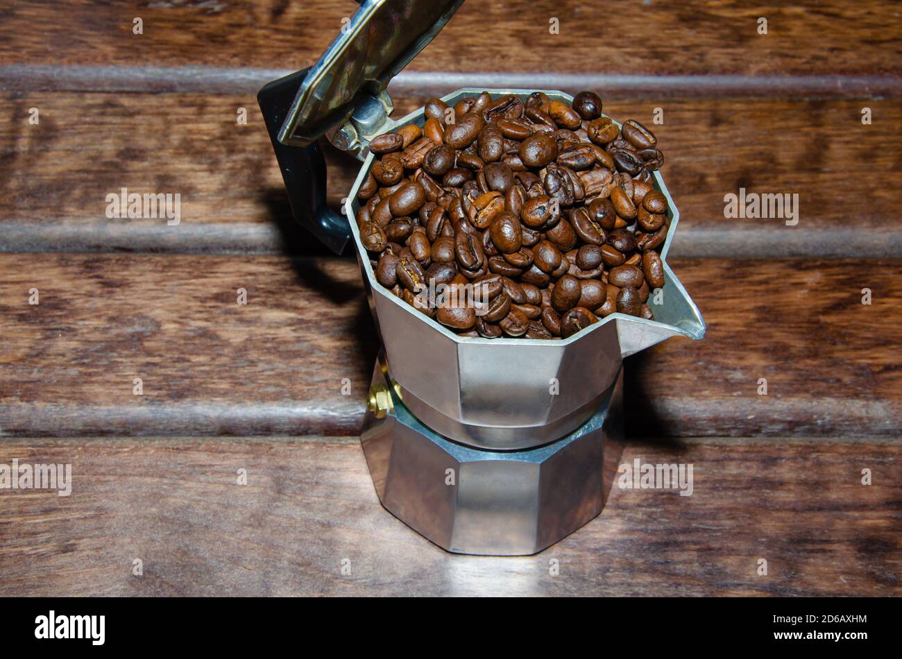 Coffee in a moka pot with coffee beans and ground coffee on blur dark