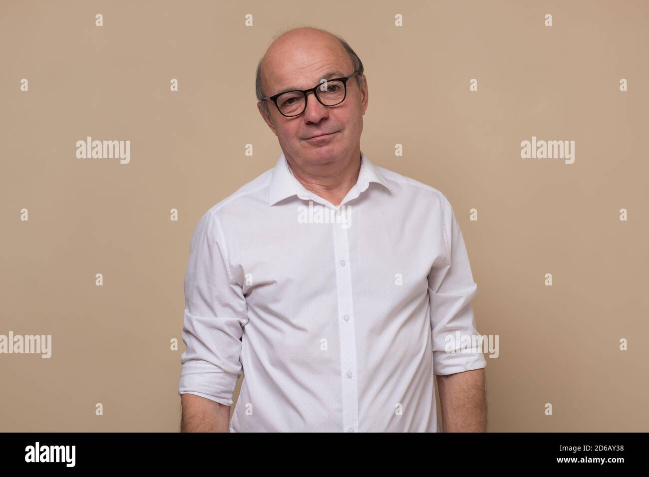 Senior man looking sadly at camera being tired. Stock Photo