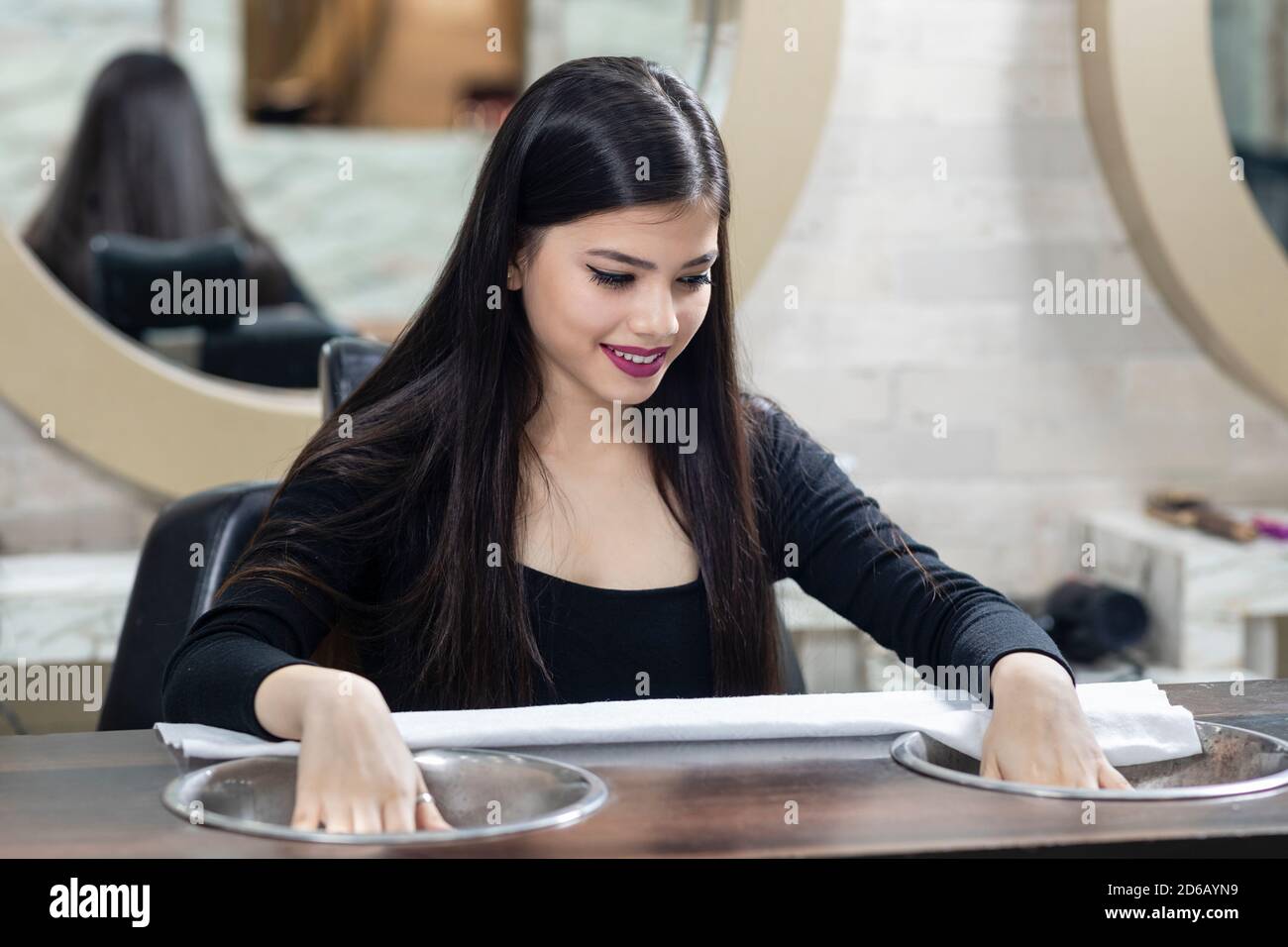 Pretty young Indian girl sitting in a salon for manicure, beauty ...
