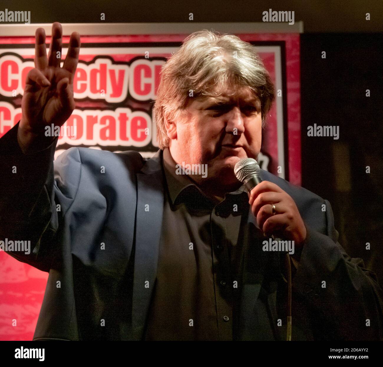 Comedian Bob Mills performs at an outdoor comedy gig in a socially