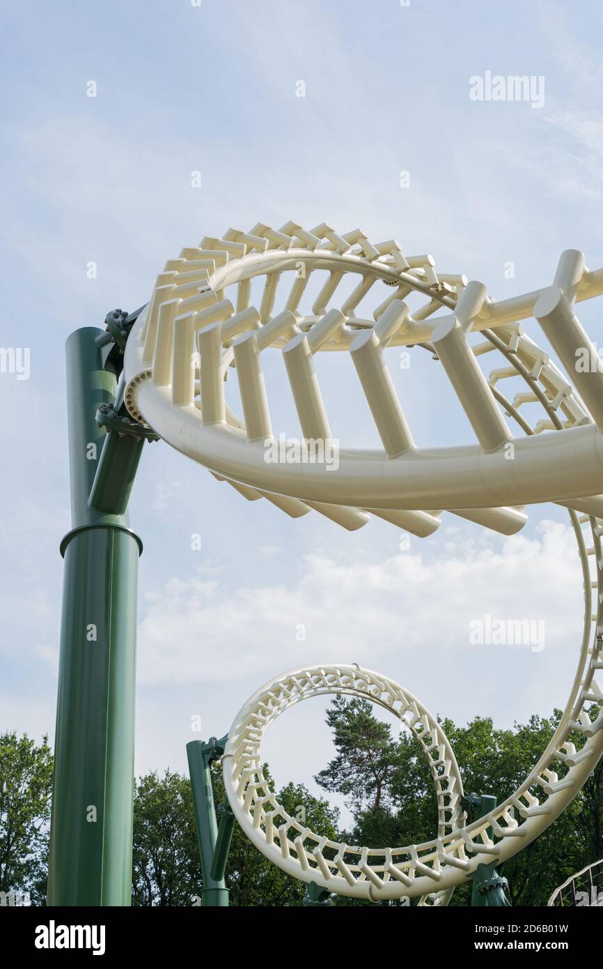 Perspective view of two inverted loops of a roller coaster against a blue  and cloudy sky Stock Photo - Alamy