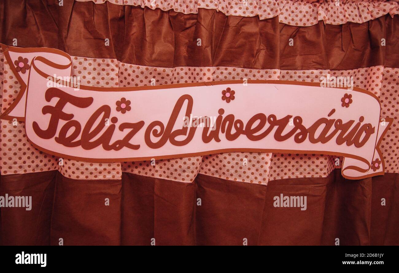 Banner 'Feliz Aniversario' on a red curtain Stock Photo