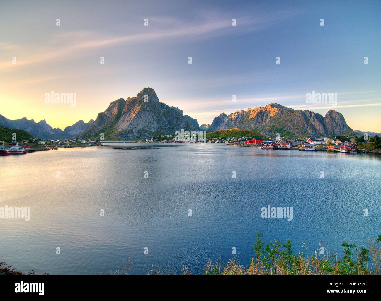 Wide Angle View To Reine On Lofoten Island Moskenesoy At Dusk On A Sunny Summer Day With A Clear Blue Sky And A Few Clouds Stock Photo