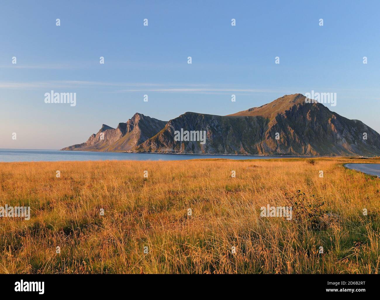 View To The Mountains Of Lofoten Island Flakstadoy In The Late Afternoon Sun On A Sunny Summer Day With A Clear Blue Sky And A Few Clouds Stock Photo