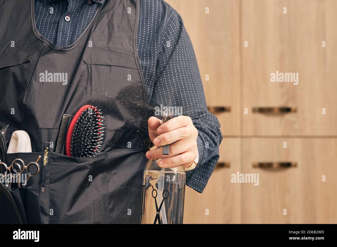 hairdresser, barber in an apron on a light background Stock Photo - Alamy