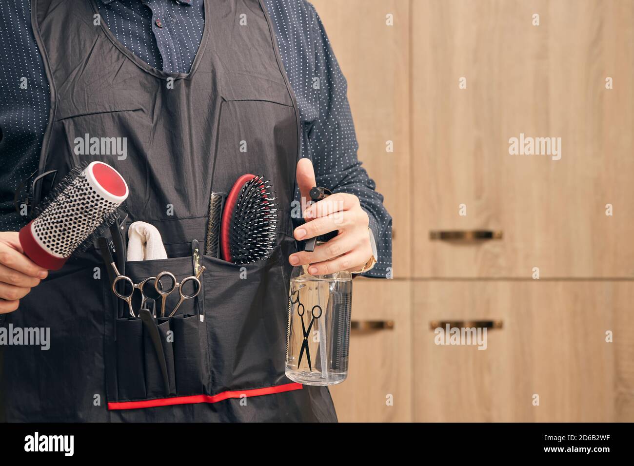 hairdresser, barber in an apron on a light background Stock Photo - Alamy