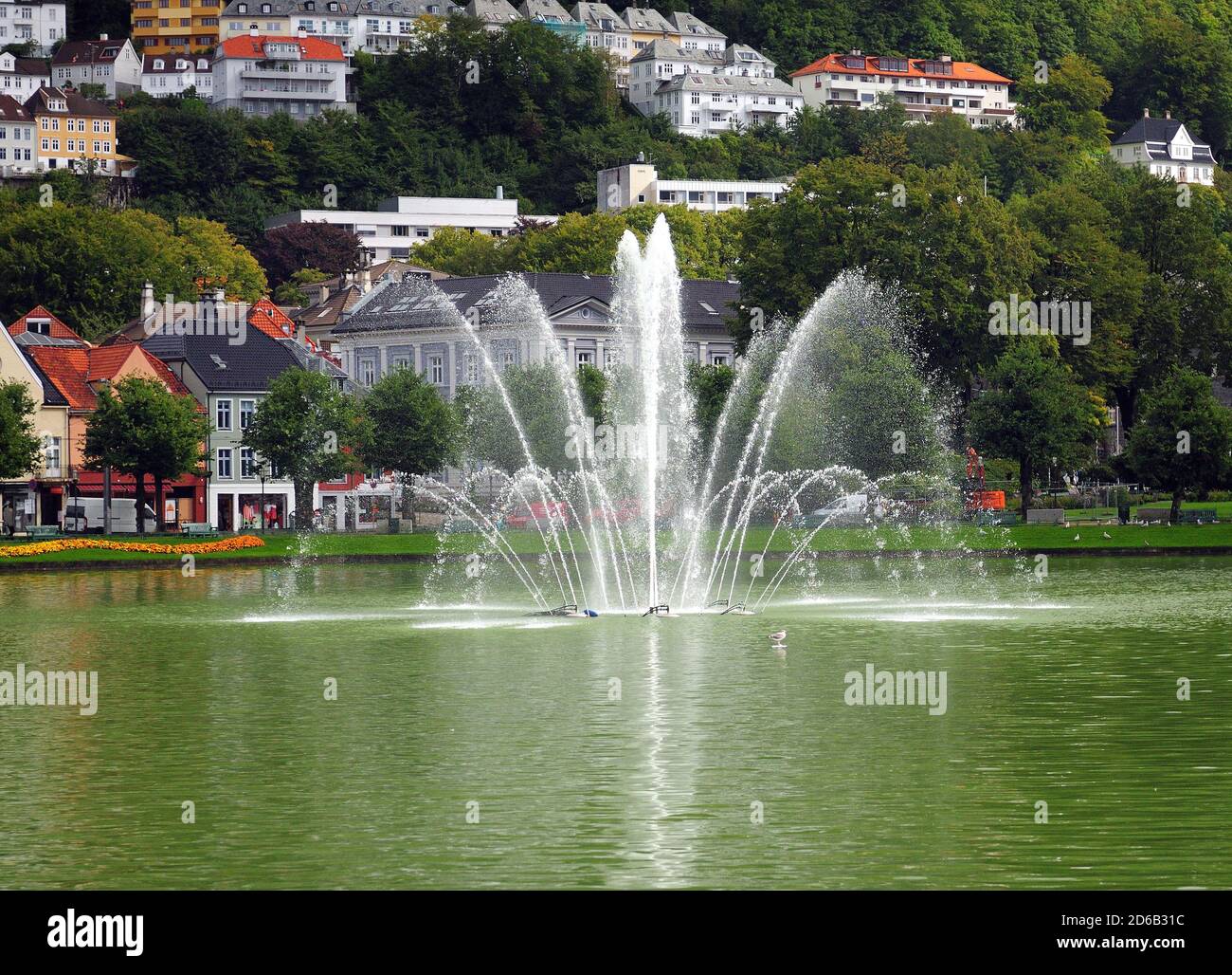 Water Fountain In The Lille Lungegardsvannet Lake In Bergen On A Sunny Summer Day With A Clear Blue Sky And A Few Clouds Stock Photo