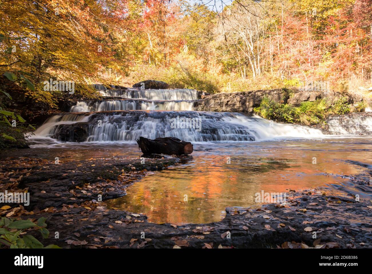 Peak fall foliage surrounds beautiful cascading Shohola Falls on an
