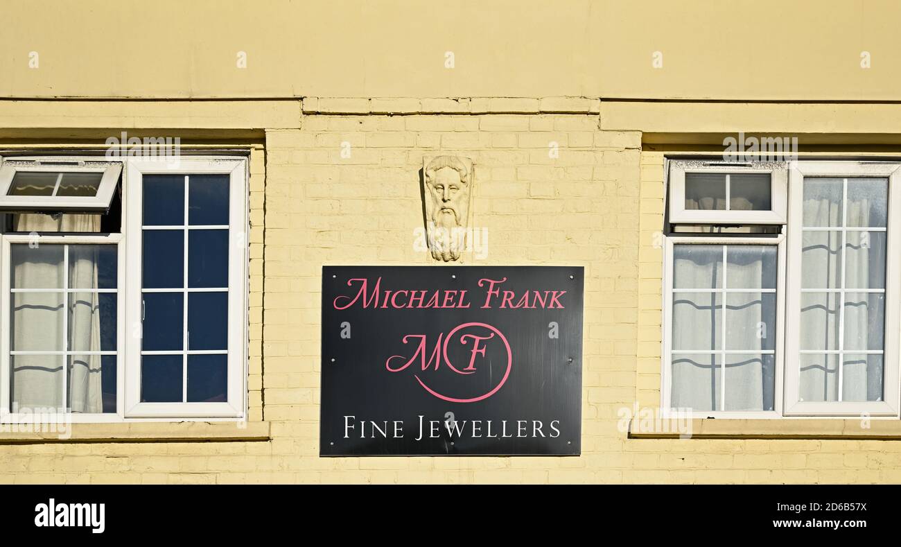 A nineteenth century building with carved face (added later) on the wall of Michael Frank, jewellers, at the Broadway in Wickford Essex. Stock Photo