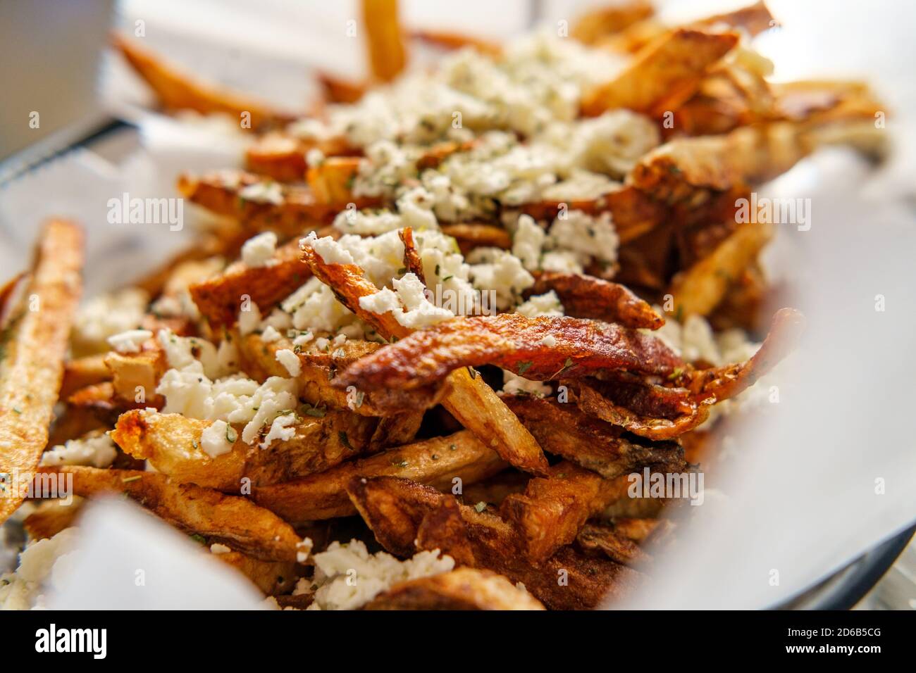 Delicious Mediterranean street cart fried potatoes with feta cheese herbs and spices Stock Photo