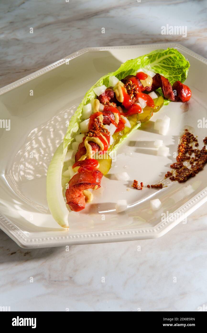 Spiralized fancy gourmet glutenfree lettuce wrap hot dog with mustard