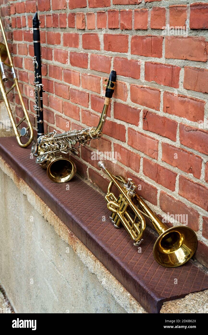 Musical instruments including trombone trumpet clarinet and saxophone on  brick wall outside Jazz club Stock Photo - Alamy