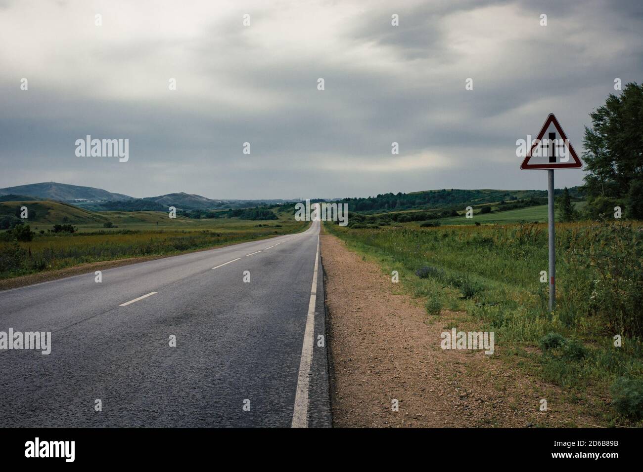 Asphalt road to the horizon line under a cloudy sky Stock Photo - Alamy