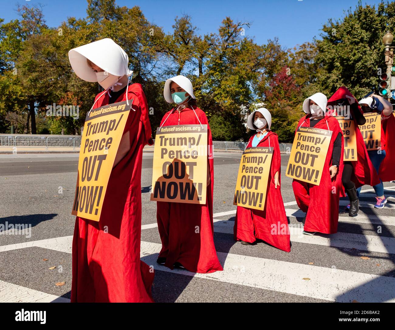 Washington, DC, USA, 15 October, 2020.  Pictured: Women and girls dressed as handmaids walk silently from their gathering point during the Descend on the Supreme Court protest held by Refuse Fascism DC.  For the event, women dressed as handmaids in red capes from The Handmaid's Tale and stood in front of the Supreme Court building to protest the nomination of Amy Coney Barrett and fascist policies of the Trump Administration.  The protest continued Refuse Fascism's demand for immediate removal of Donald Trump and Mike Pence from office.  Credit: Allison C Bailey/Alamy Live News Stock Photo