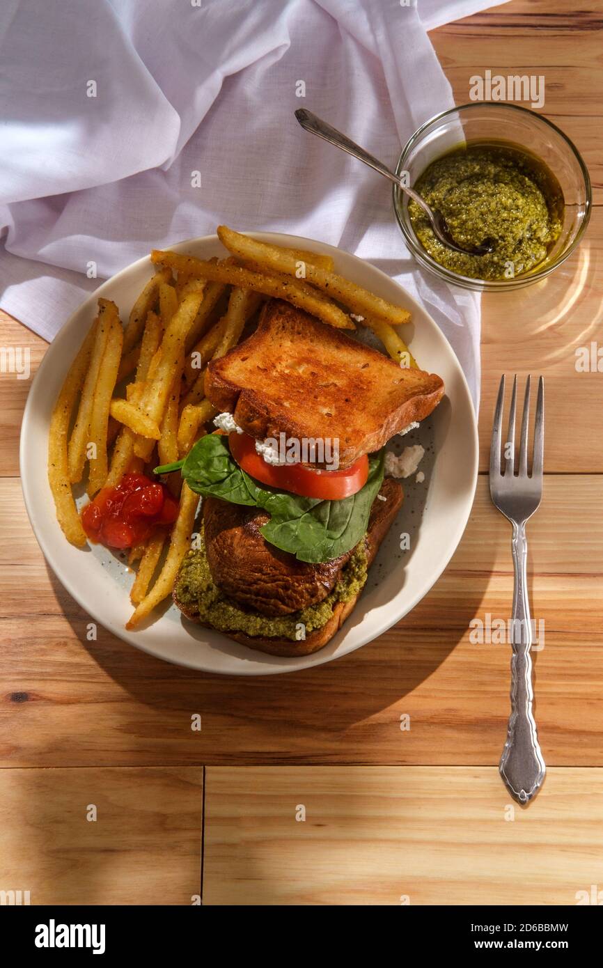 Portobello mushroom sandwich with goat cheese pesto and side of french fries Stock Photo Alamy
