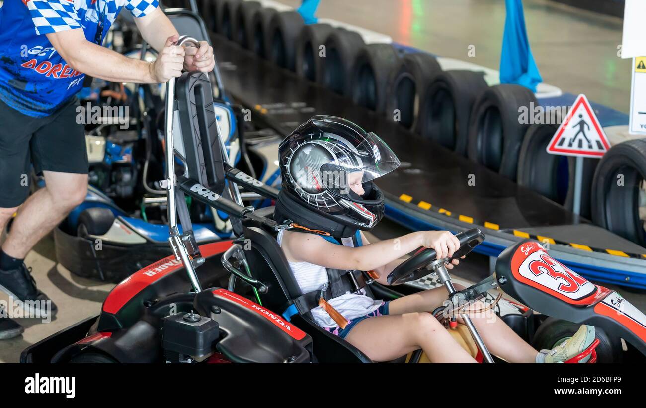 Mackay, Queensland, Australia - January 2020: A young girl drives a go-kart in a fun race around an indoor circuit Stock Photo