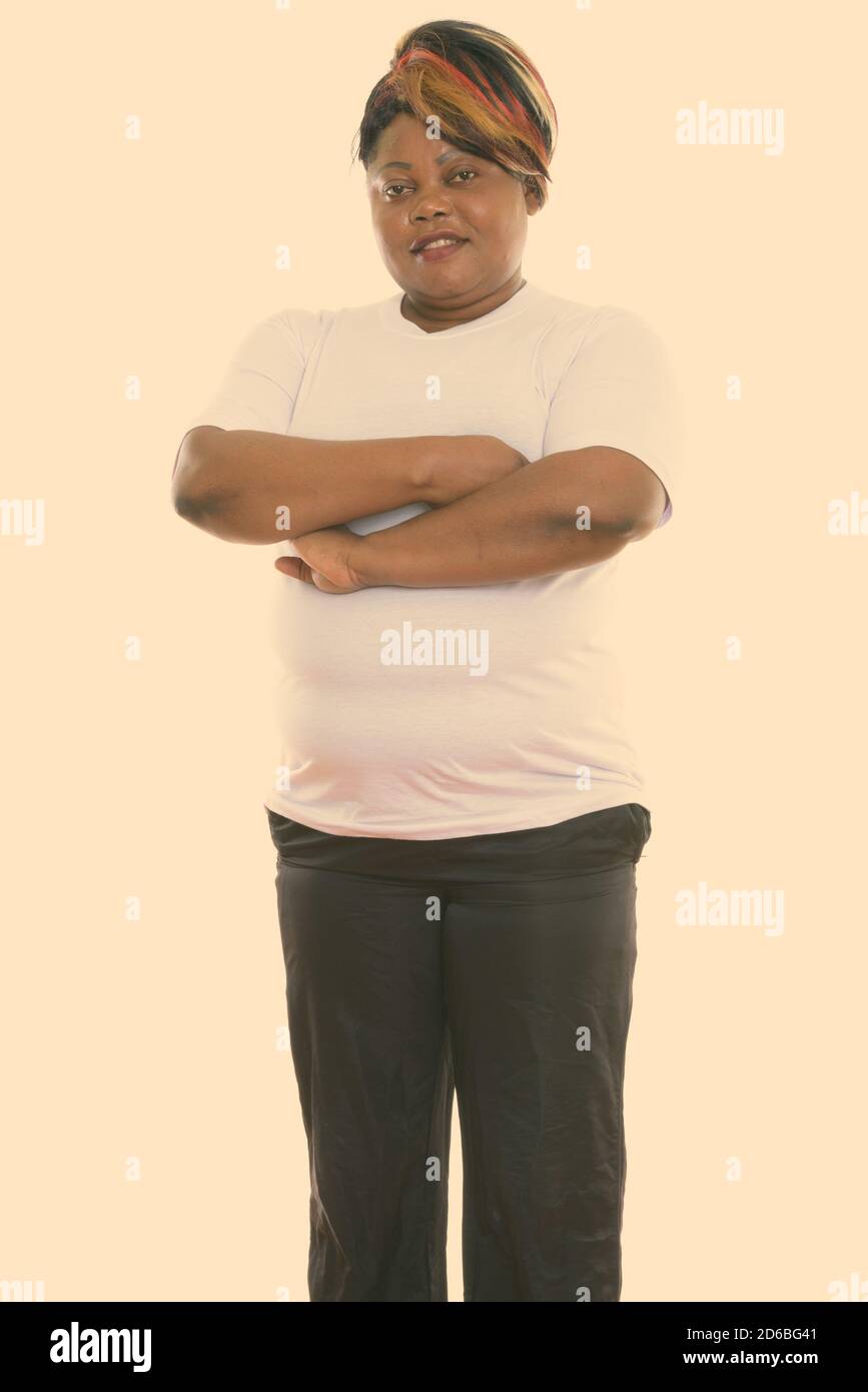Studio shot of happy fat black African woman smiling and standing with ...