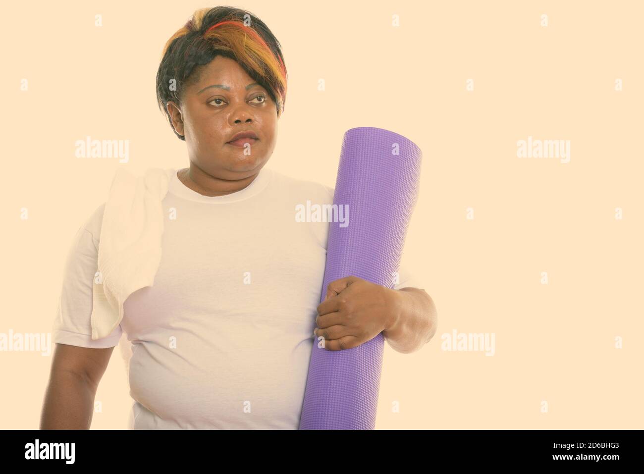 Studio shot of fat black African woman thinking while holding yoga mat ...