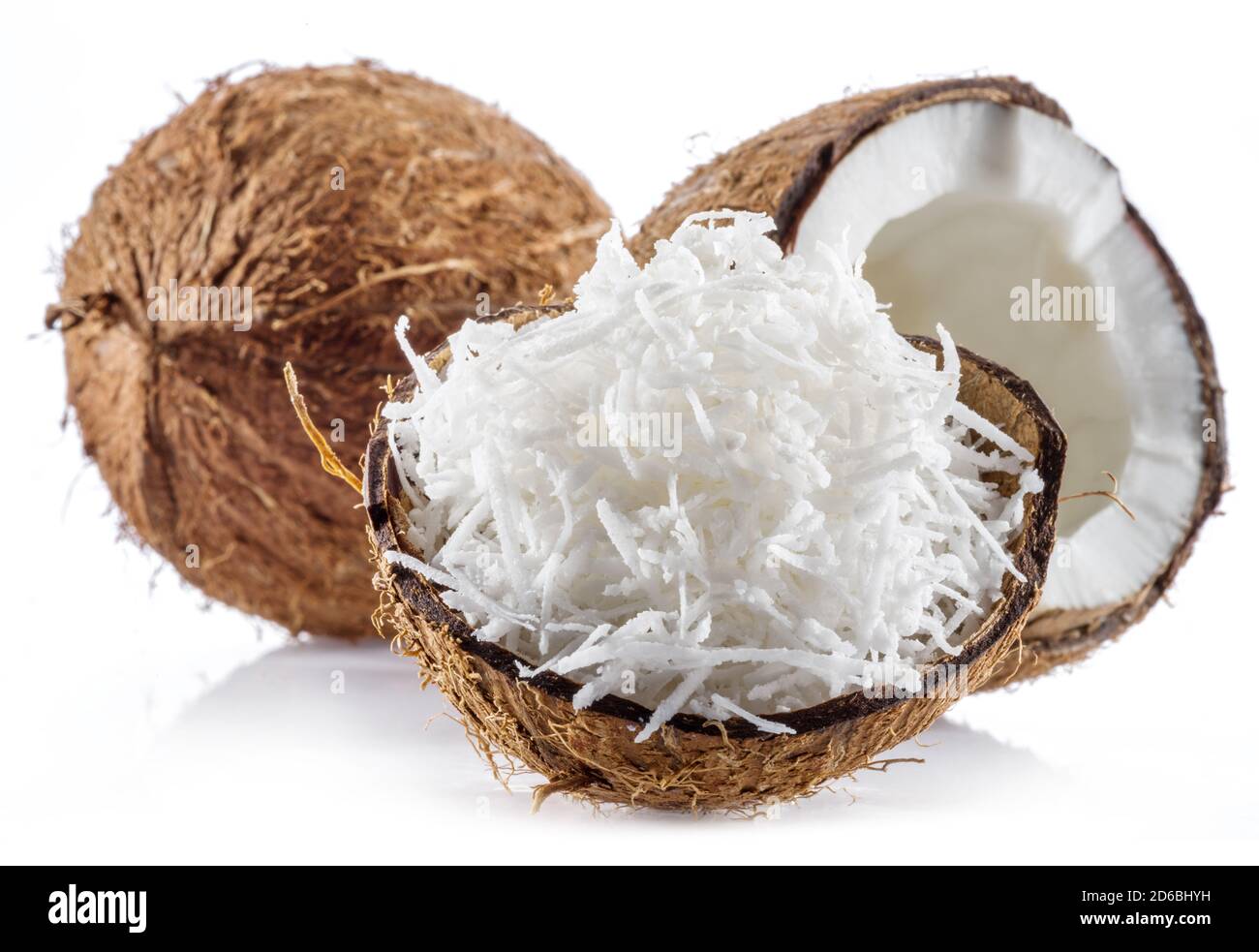 Coconut fruit and shredded coconut flakes in the piece of shell isolated on white background. Stock Photo