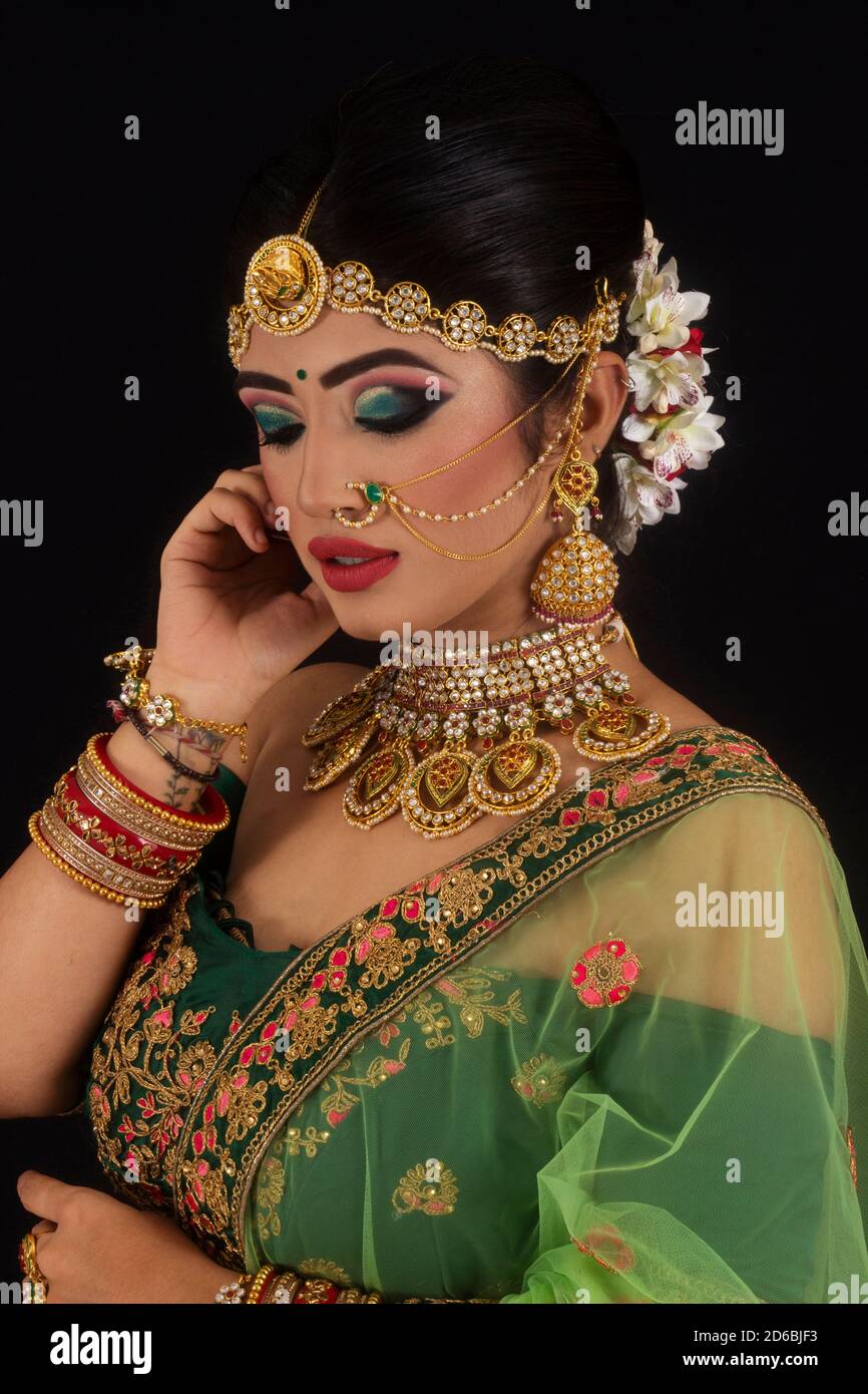 Woman in bridal green sari and gold jewelry. Eyes closed. Side profile Stock Photo