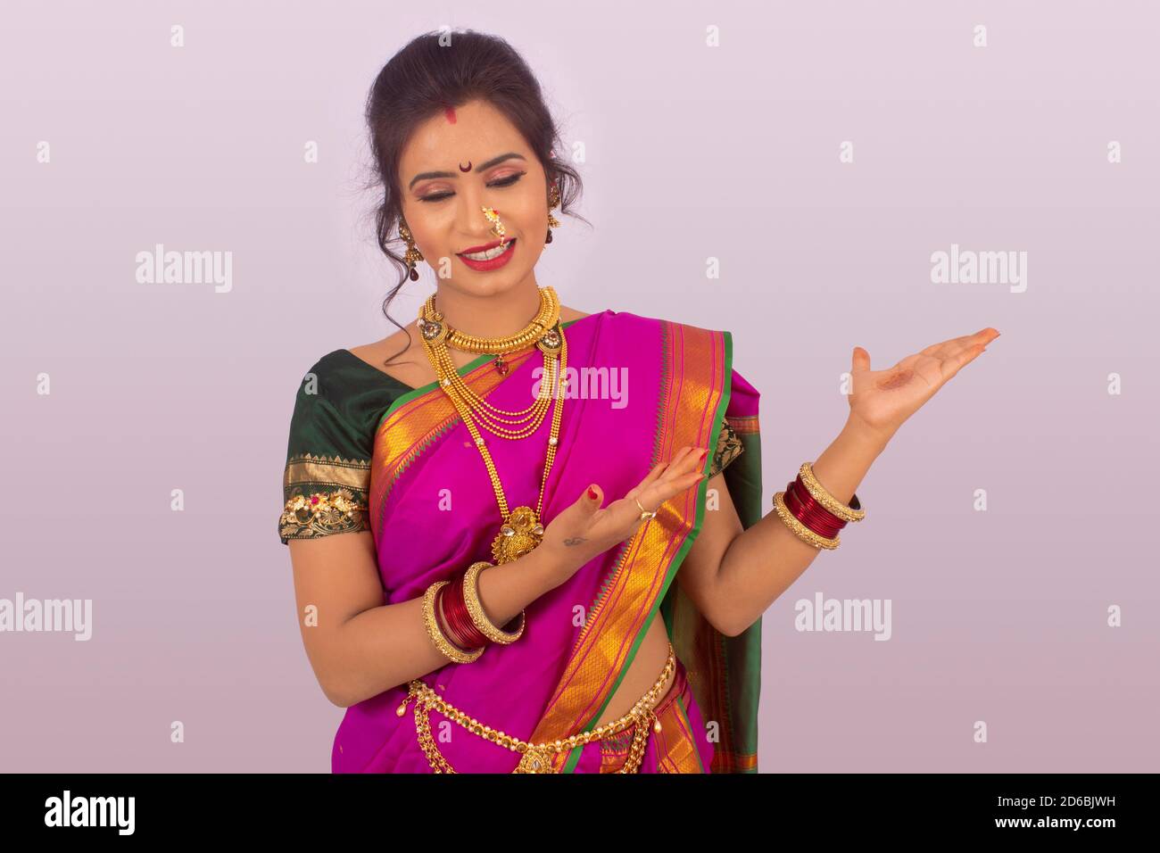 Portrait of Pretty Young Indian Girl Wearing Traditional Saree, Gold  Jewellery and Bangles Holding Lotus Flower in Her Hands in Stock Image -  Image of indian, decoration: 233255875