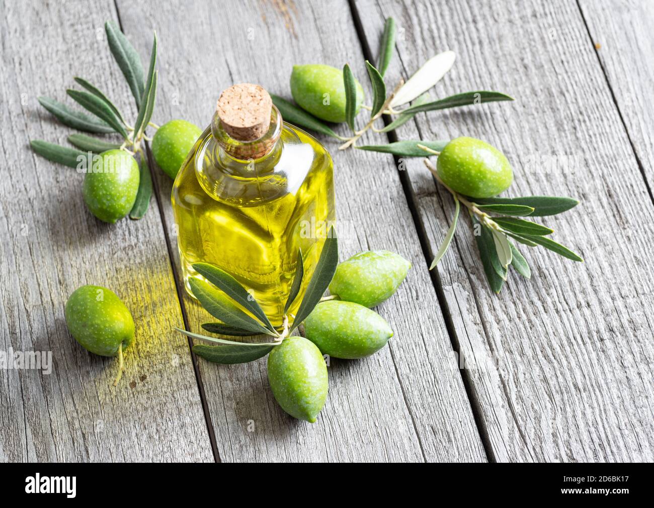 Green natural olives with bottle of olive oil on a vintage old wooden ...