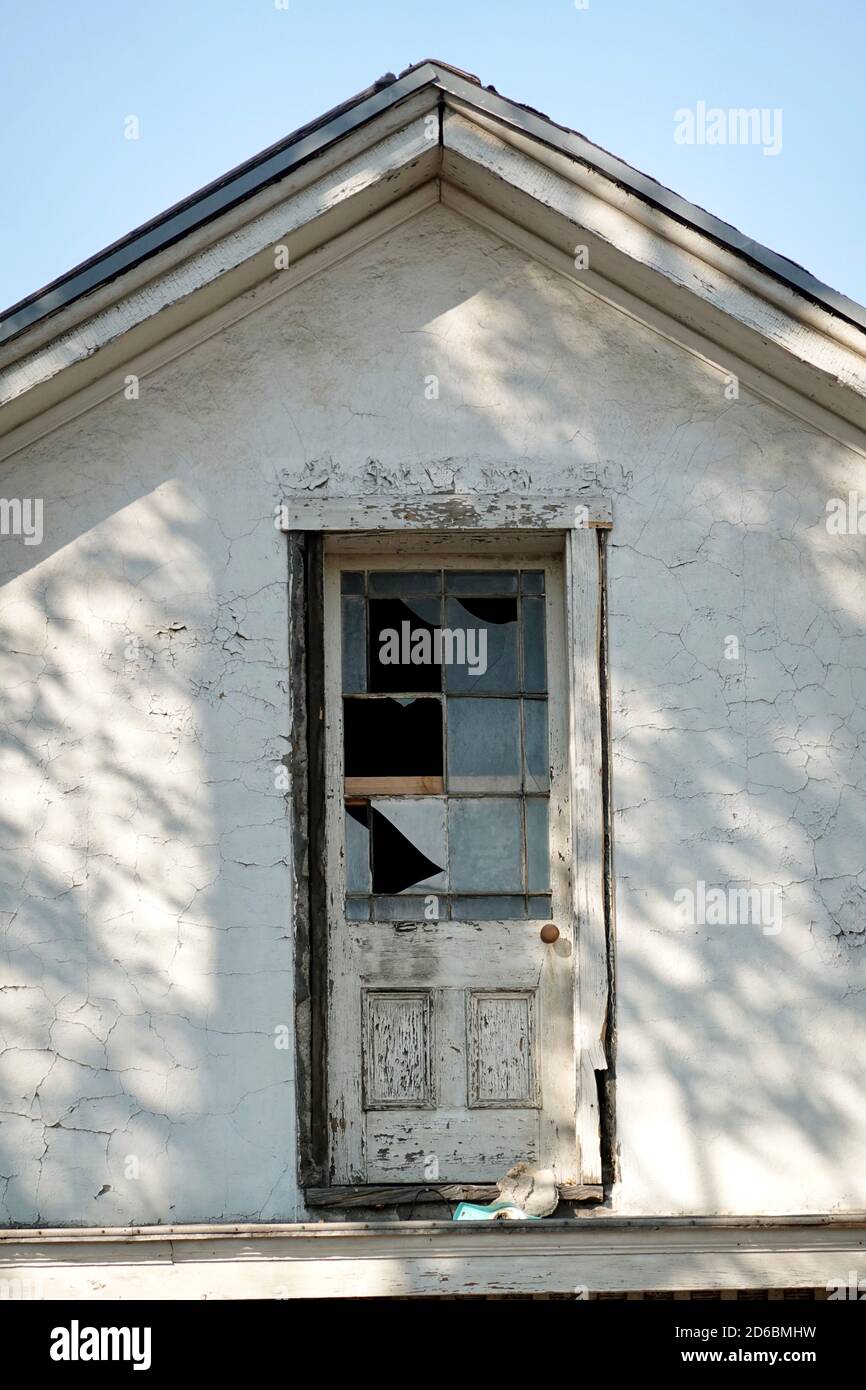 An abandoned boarded up house with trash all around. Stock Photo